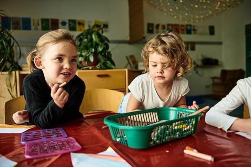 Zwei Kinder am Tisch in einer Kita beim Malen