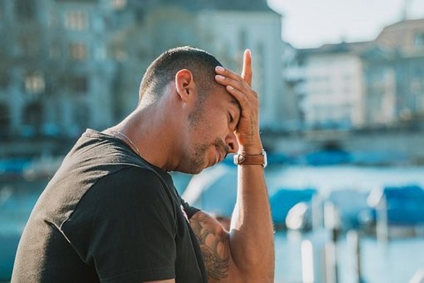 Mann von der Seite - stützt den Kopf in die Hand