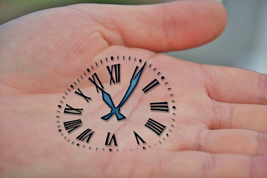 Zifferblatt einer Uhr in eine Handfläche gezeichnet - die Zeiger stehen auf 11:06 Uhr