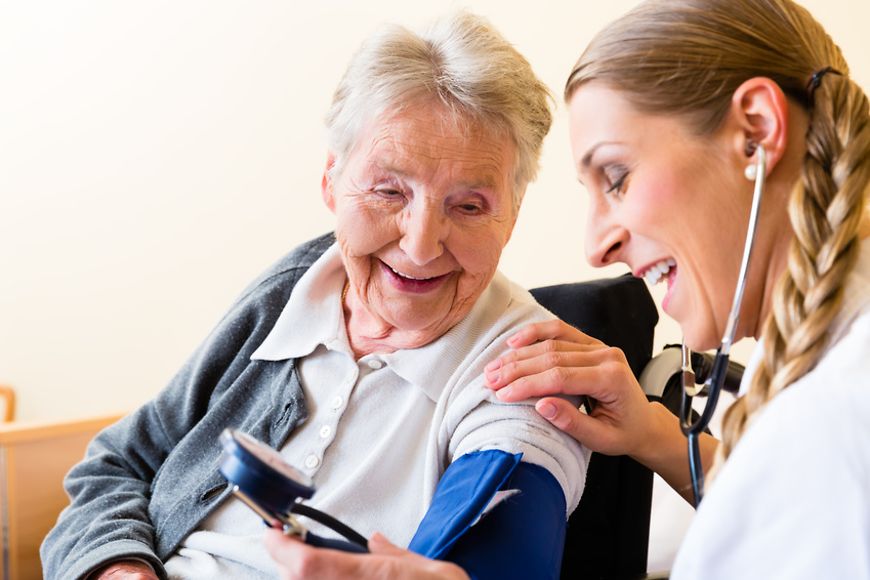 Pflegefachkraft misst bei älterer Dame den Blutdruck