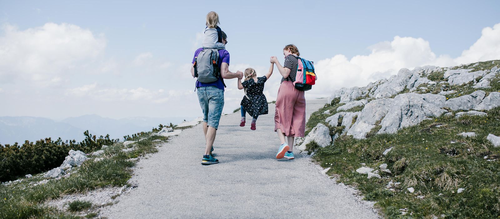 Eine junge Familie im Urlaub beim Wandern auf einen Berg
