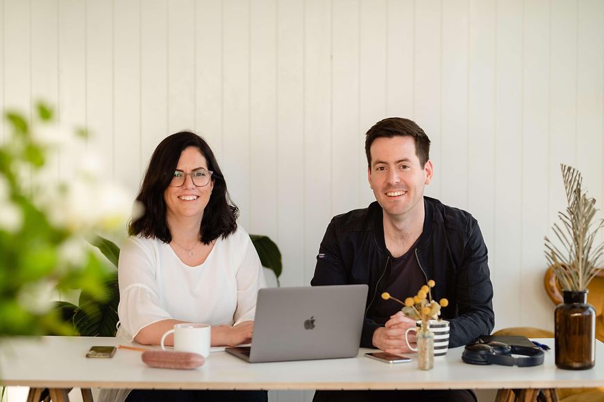 Frau und Mann am Schreibtisch mit Laptop