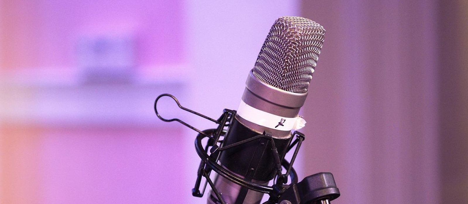Mikrofon auf Mikrofonständer, lila Hintertergrund