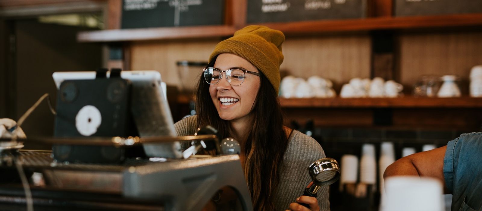 Junge Frau hinter einem Tresen - Coffee-Shop