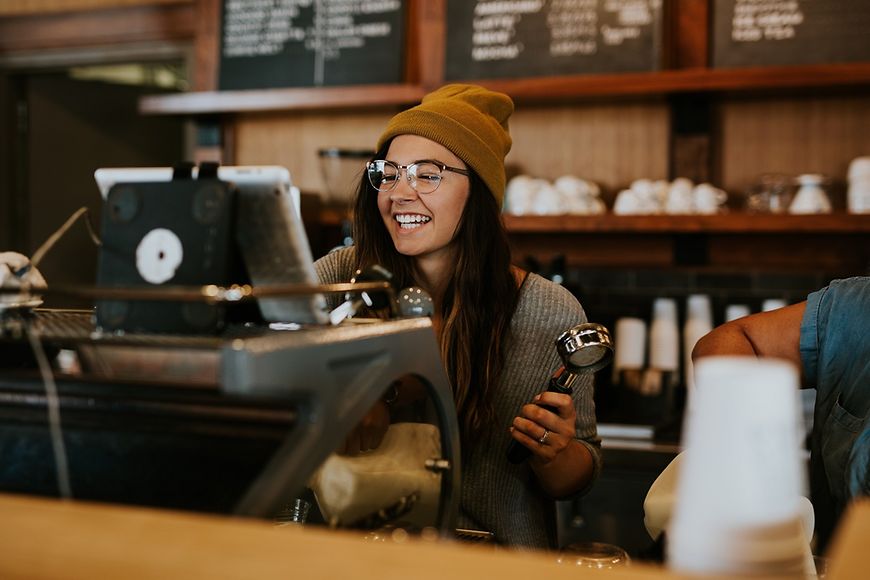 Junge Frau hinter einem Tresen - Coffee-Shop