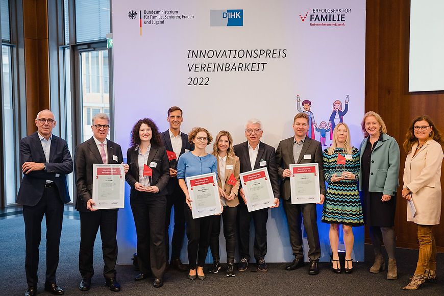 Mehrere Personen u.a. Bundesfamilienministerin Lisa Paus, stehen vor einer Pressewand "Innovationspreis Vereinbarkeit 2022"