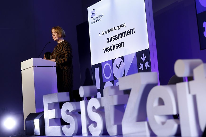 Bundesfamilienministerin Lisa Paus steht an einem Rednerpult, daneben stehen die großen Buchstaben "Es ist Zeit"