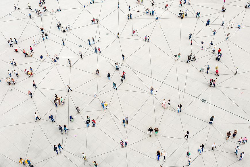 Blick von oben zeigt Menschen, die durch viele Linien wie in einem Spinnennetz miteinander verbunden sind. 
