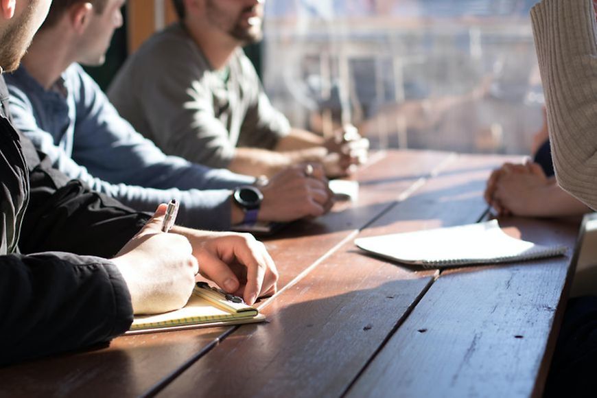 Männer sitzen am Tisch und reden