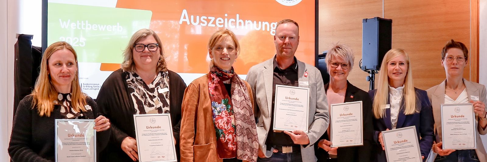 Gruppenfoto von Karin Prien und anderen vor Leinwand